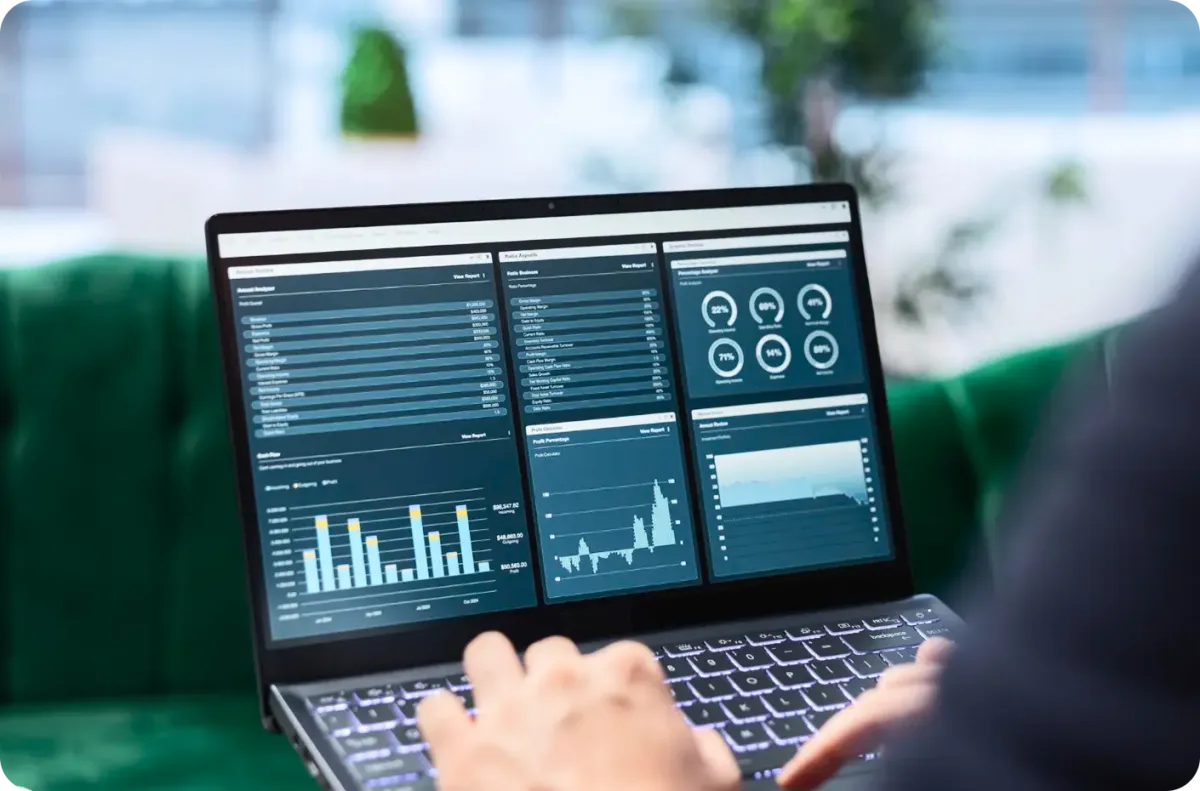 Person analyzing data on laptop with dashboards